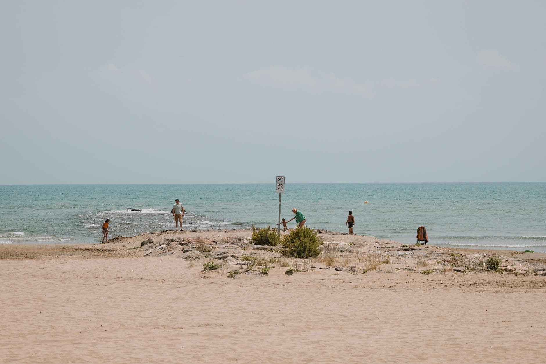 Rodzina z dziećmi na piaszczystej plaży w Hiszpanii przy zachodzie słońca