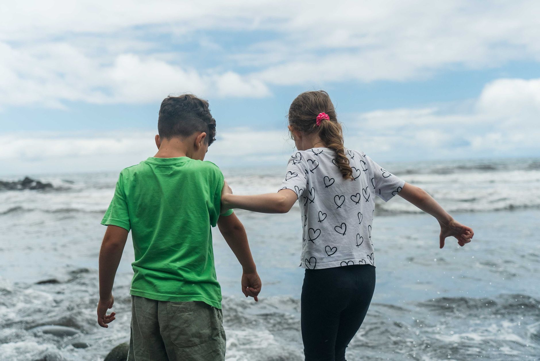 Czarna wulkaniczna plaża Playa Jardín z palmami i widokiem na góry, Puerto de la Cruz, Teneryfa