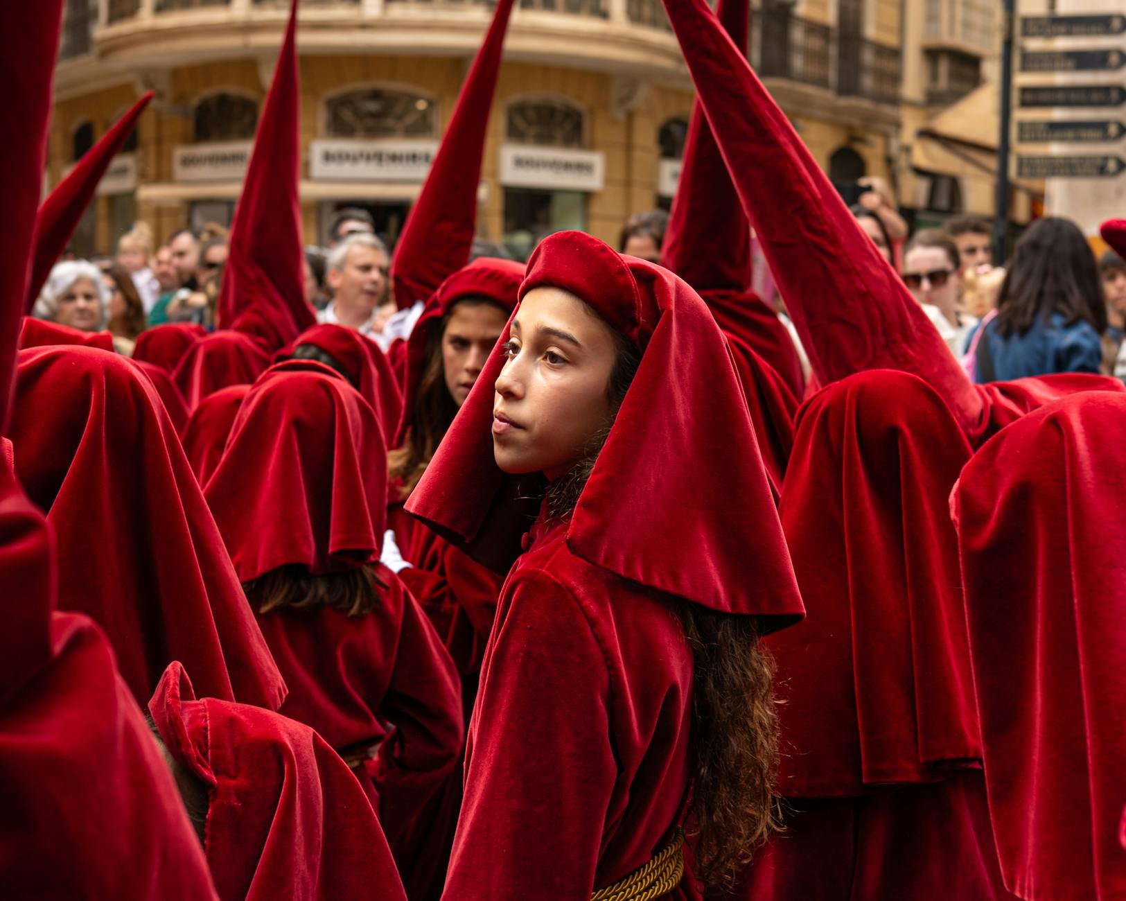 Procesja Semana Santa nocą w Sewilli — tłum widzów ogląda pasos przy świecach
