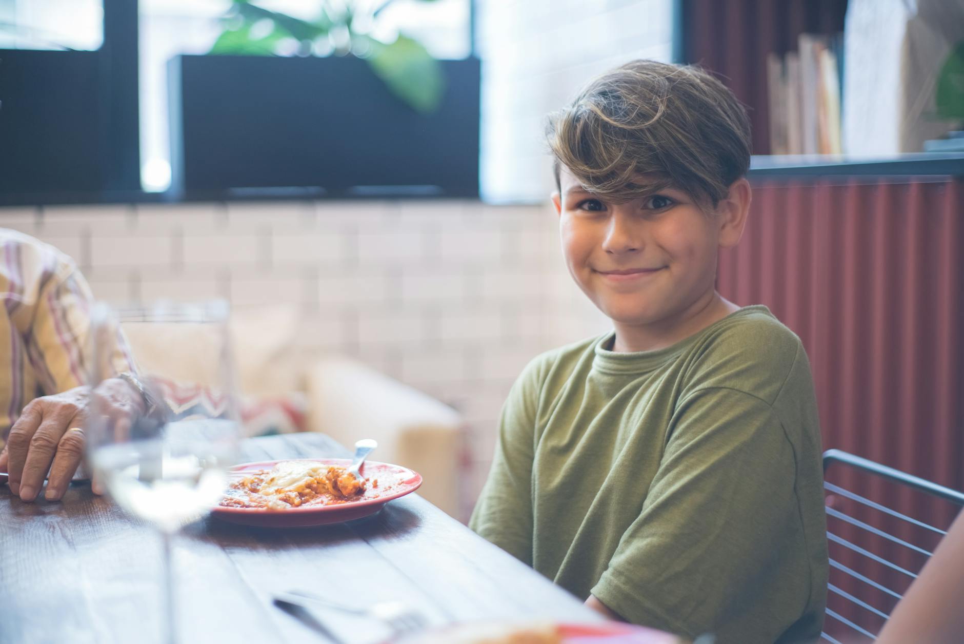 Rodzina z dziećmi przy stoliku w hiszpańskiej restauracji, menu z oznaczeniami alergenów na stole