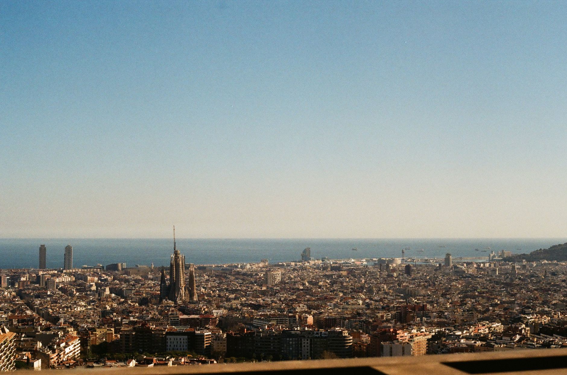 Rodzina z dziećmi na tle kolorowej mozaiki w Parku Güell w Barcelonie