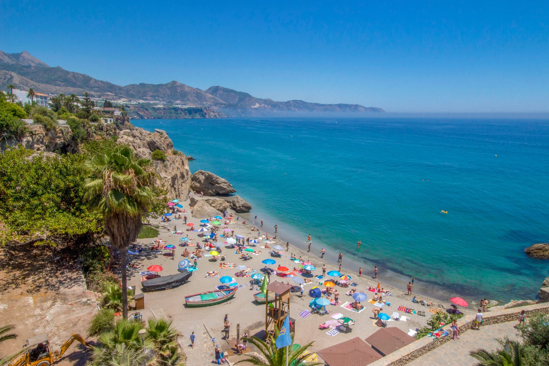 Rodzina z dziećmi bawiąca się na piaszczystej plaży Costa del Sol