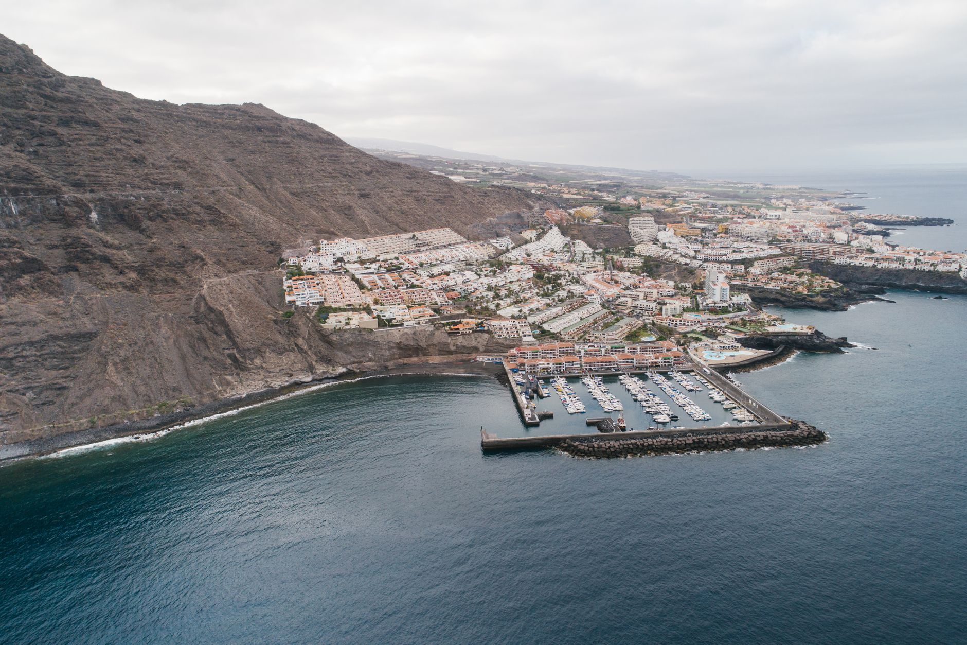 Stunning aerial view of Los Gigantes marina and cliffside town in Tenerife, Spain.