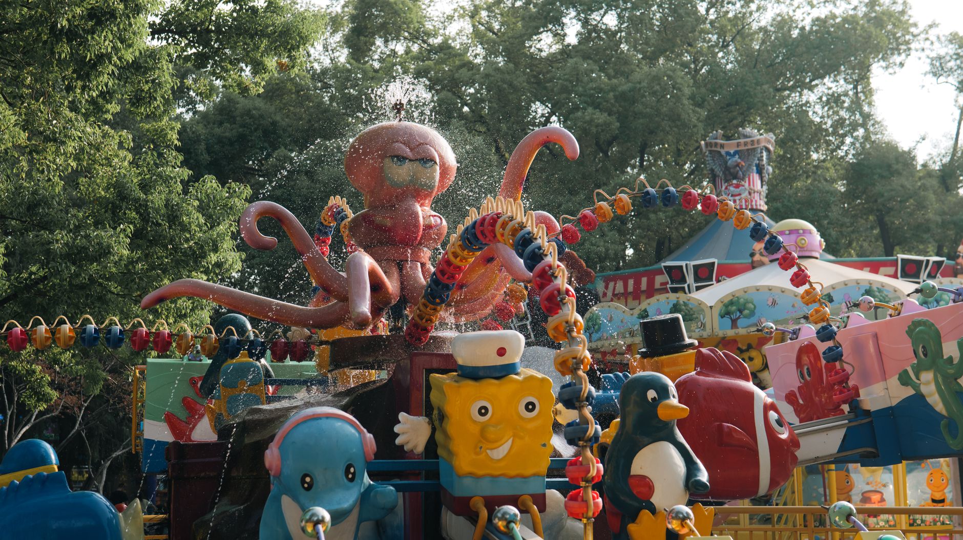 Vibrant carousel ride featuring playful octopus and cartoon figures in a park setting.
