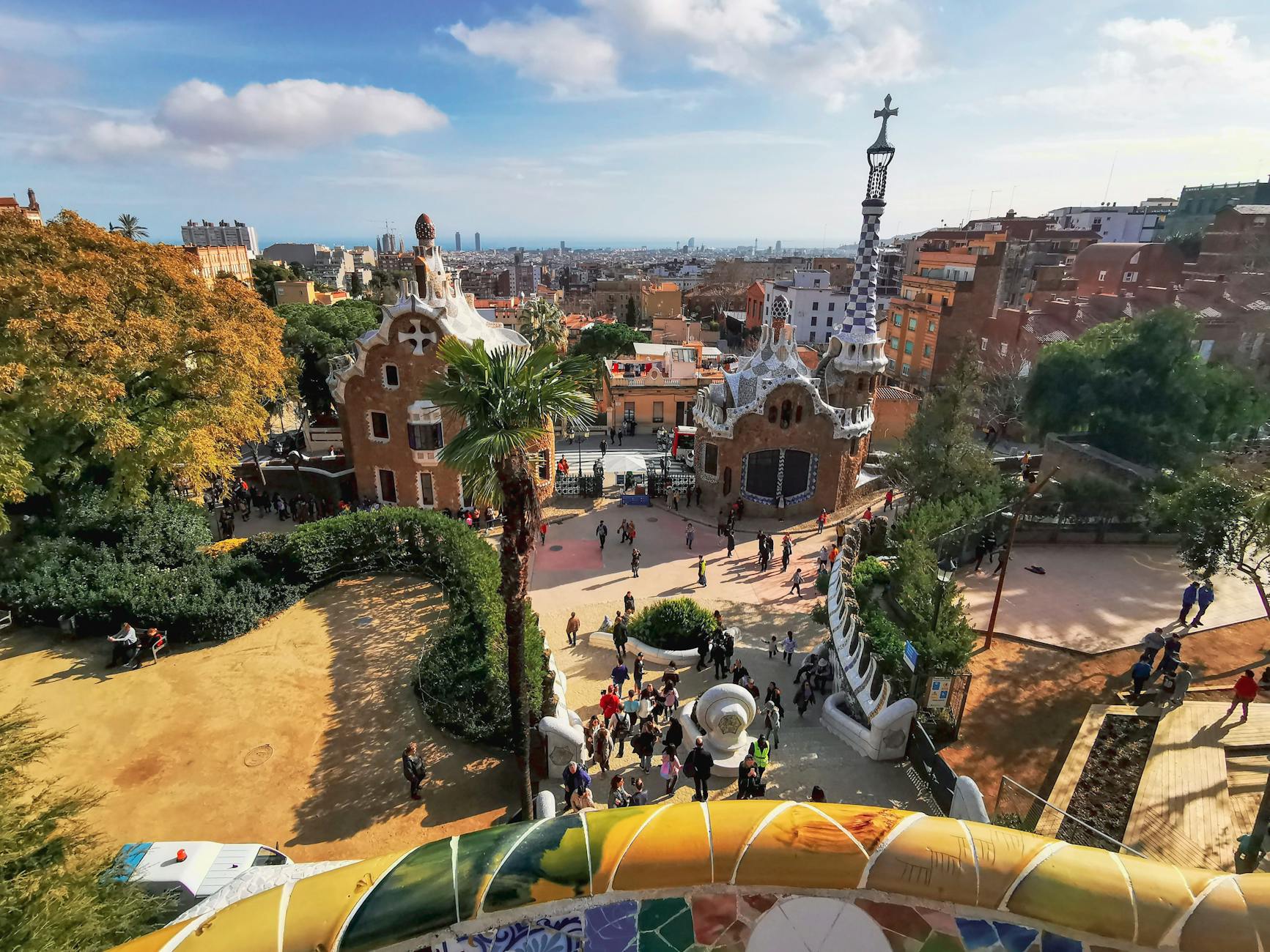 Aerial view of Park Güell in Barcelona, showcasing colorful architecture and cityscape.