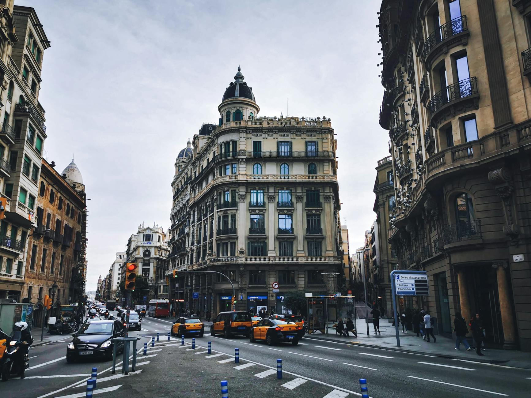 Historic street view of Barcelona&rsquo;s urban intersection with traditional architecture and traffic.