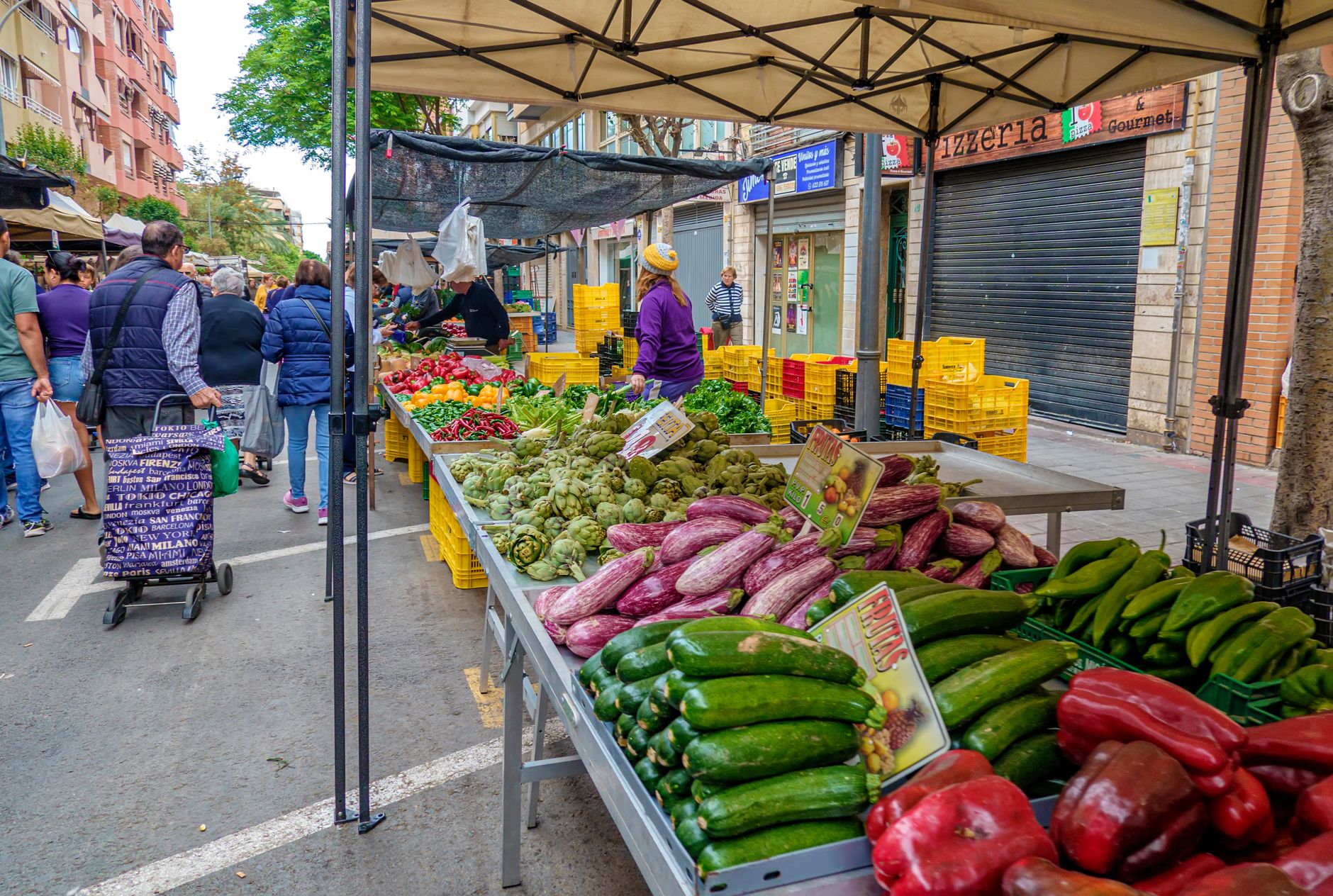 Discover vibrant market stalls with fresh produce in Alicante, Spain&rsquo;s lively street atmosphere.