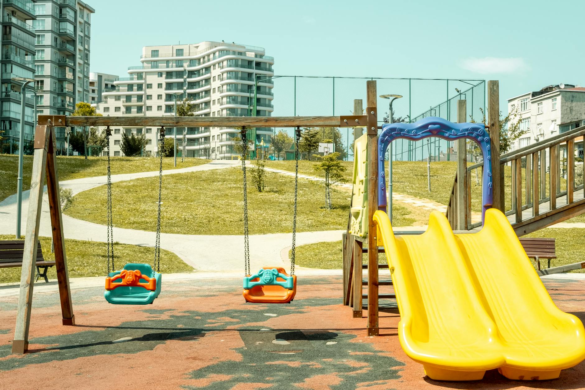 Colorful playground with swings and slide, perfect for outdoor fun and leisure.