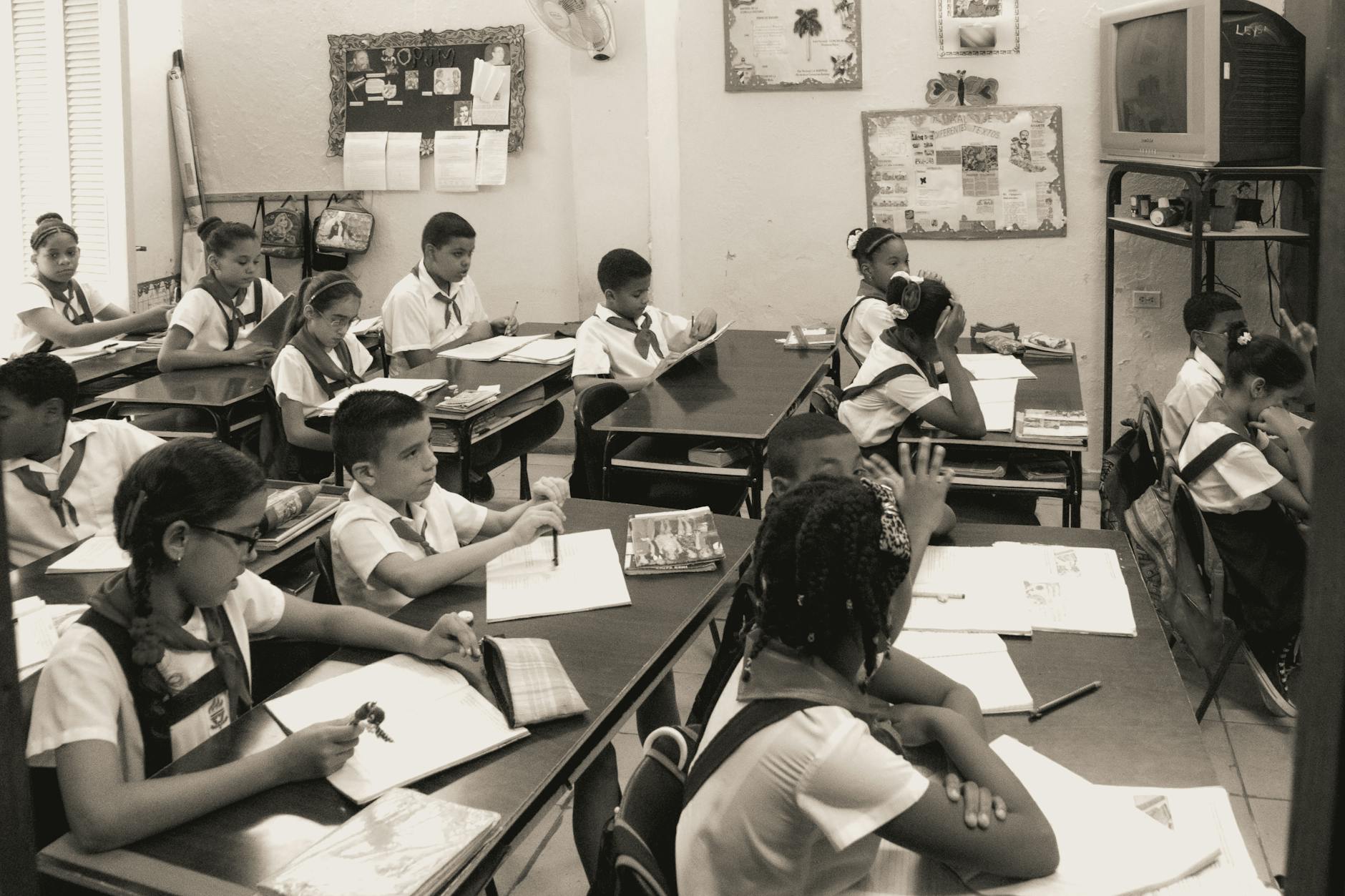 A classroom of attentive school children studying at their desks in uniform.