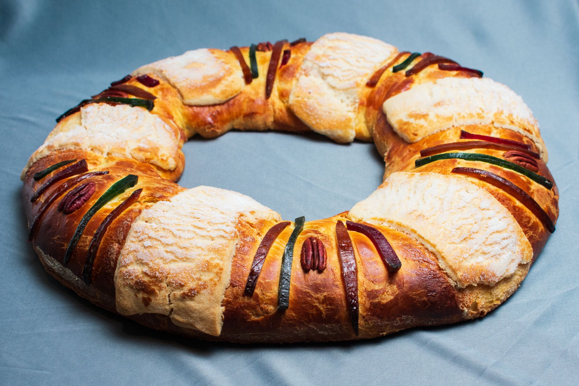 Delicious Rosca de Reyes cake, a Mexican tradition, featuring vibrant fruits and pecans.