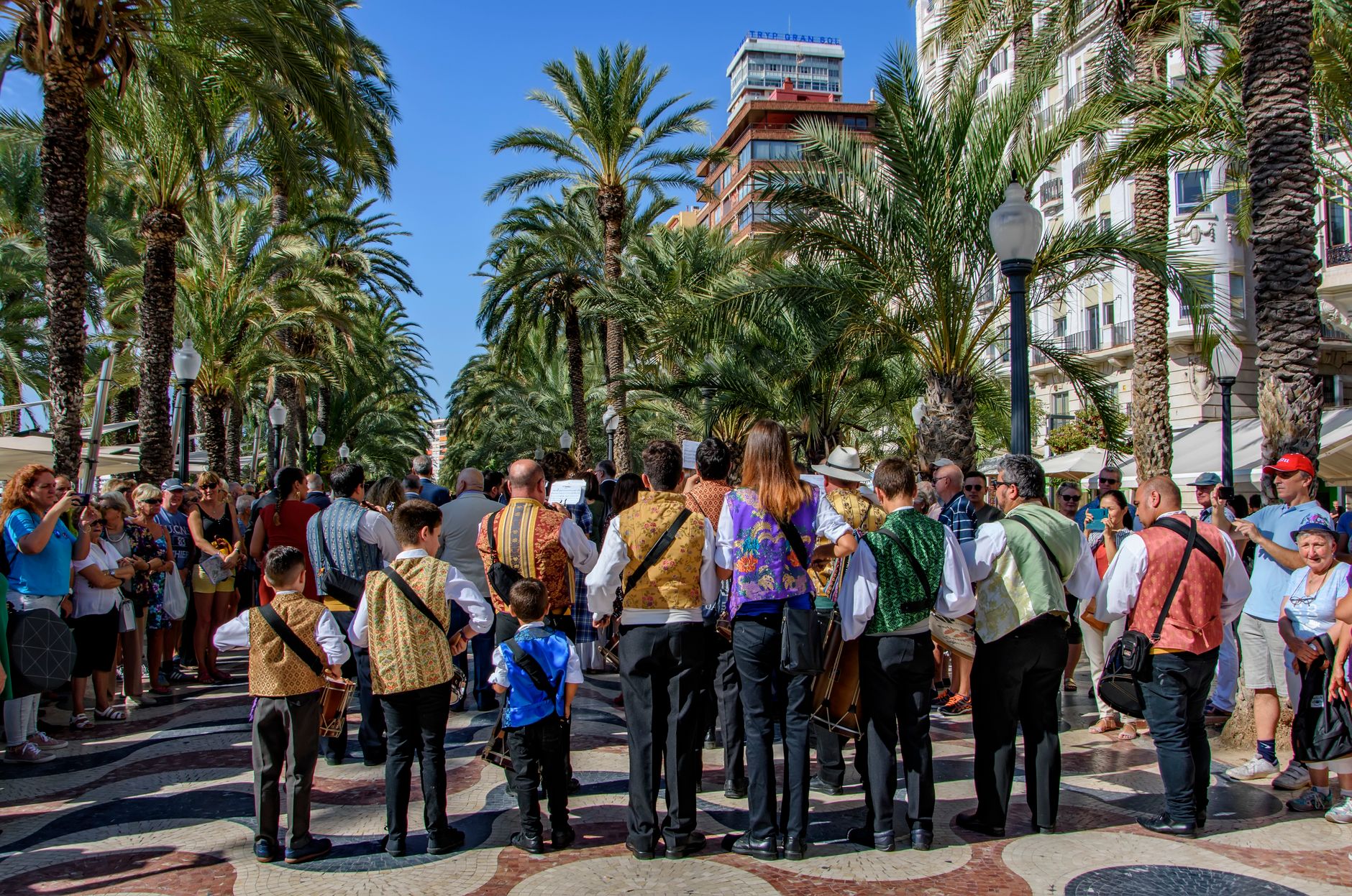 A vibrant street festival with musicians and crowd in Alicante, Spain.