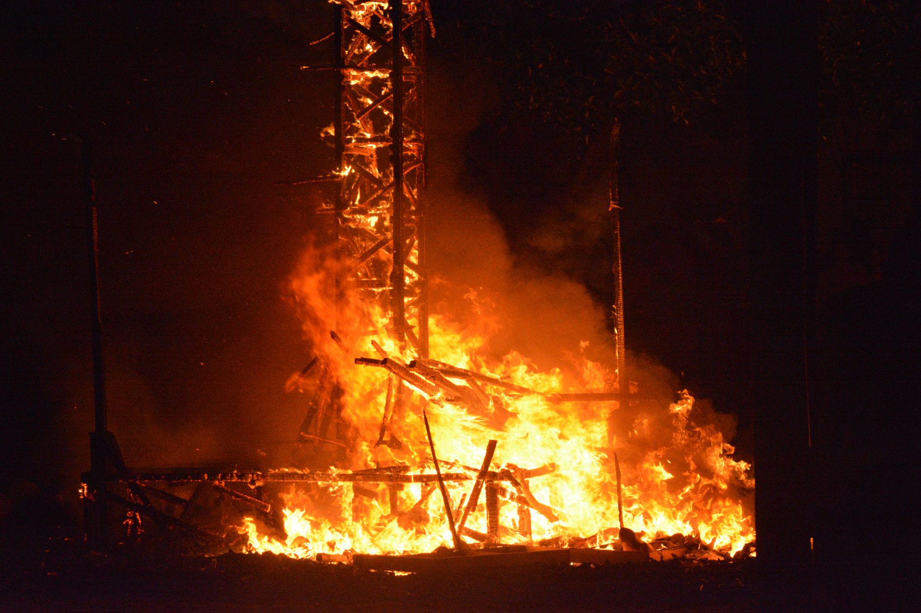 A vivid bonfire ignites during the San Juan Festival in Alicante, Spain, showcasing bright flames and intense heat.