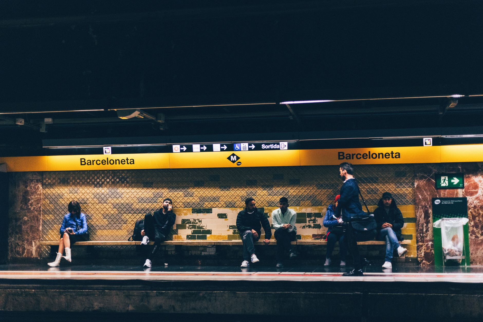Commuters wait at Barceloneta Metro station in Barcelona, Spain, showcasing urban daily life.