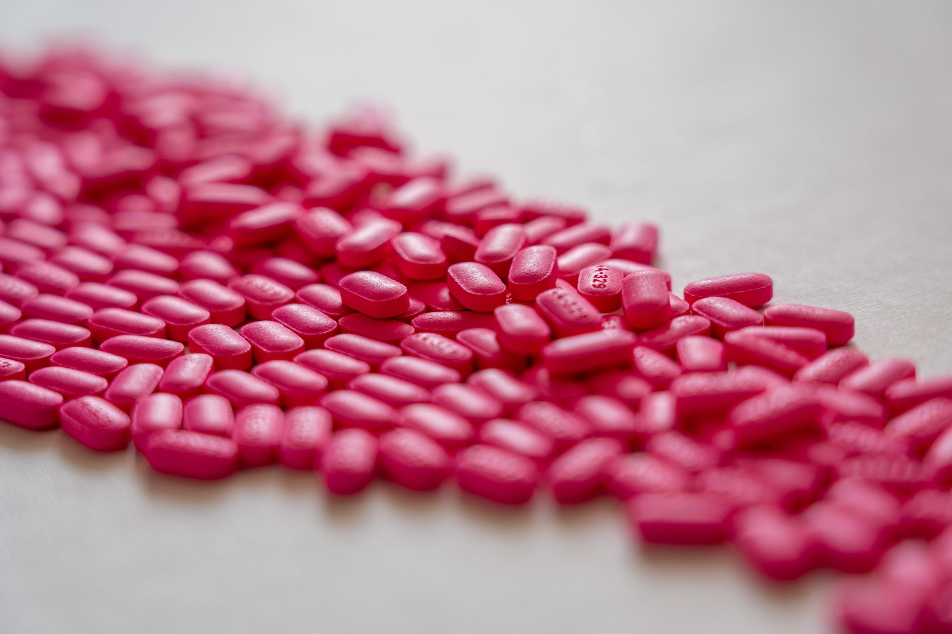 A detailed array of pink pills on a white surface, ideal for health and pharmacy topics.