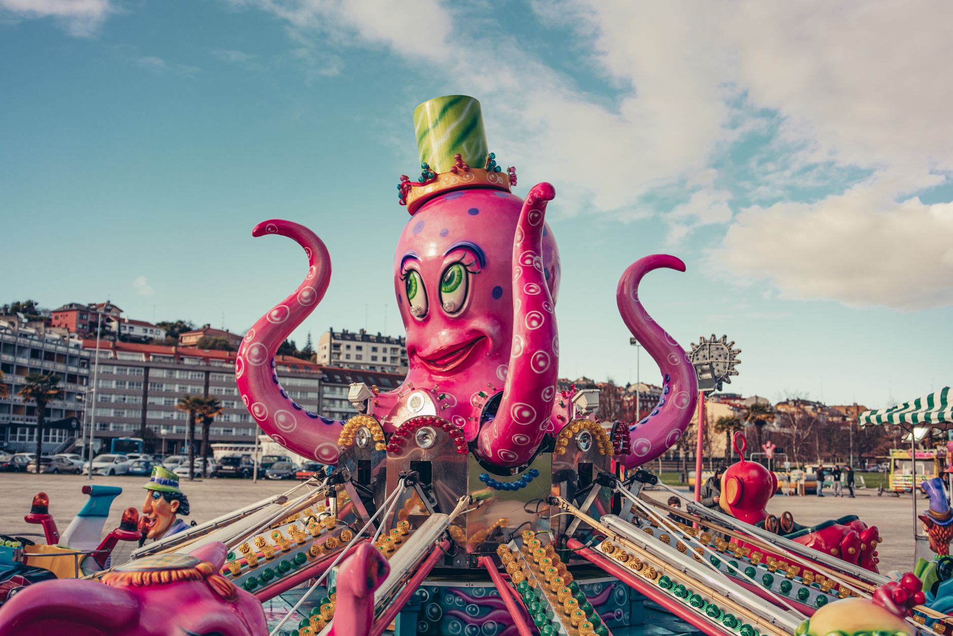 A colorful octopus-themed ride in a vibrant amusement park with blue skies in Sada, Spain.