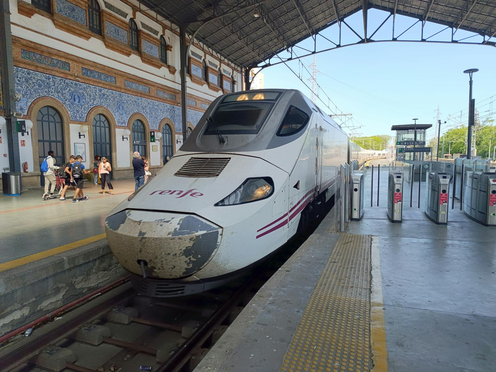 Modern train at Jerez de la Frontera railway station, capturing a lively scene with passengers.