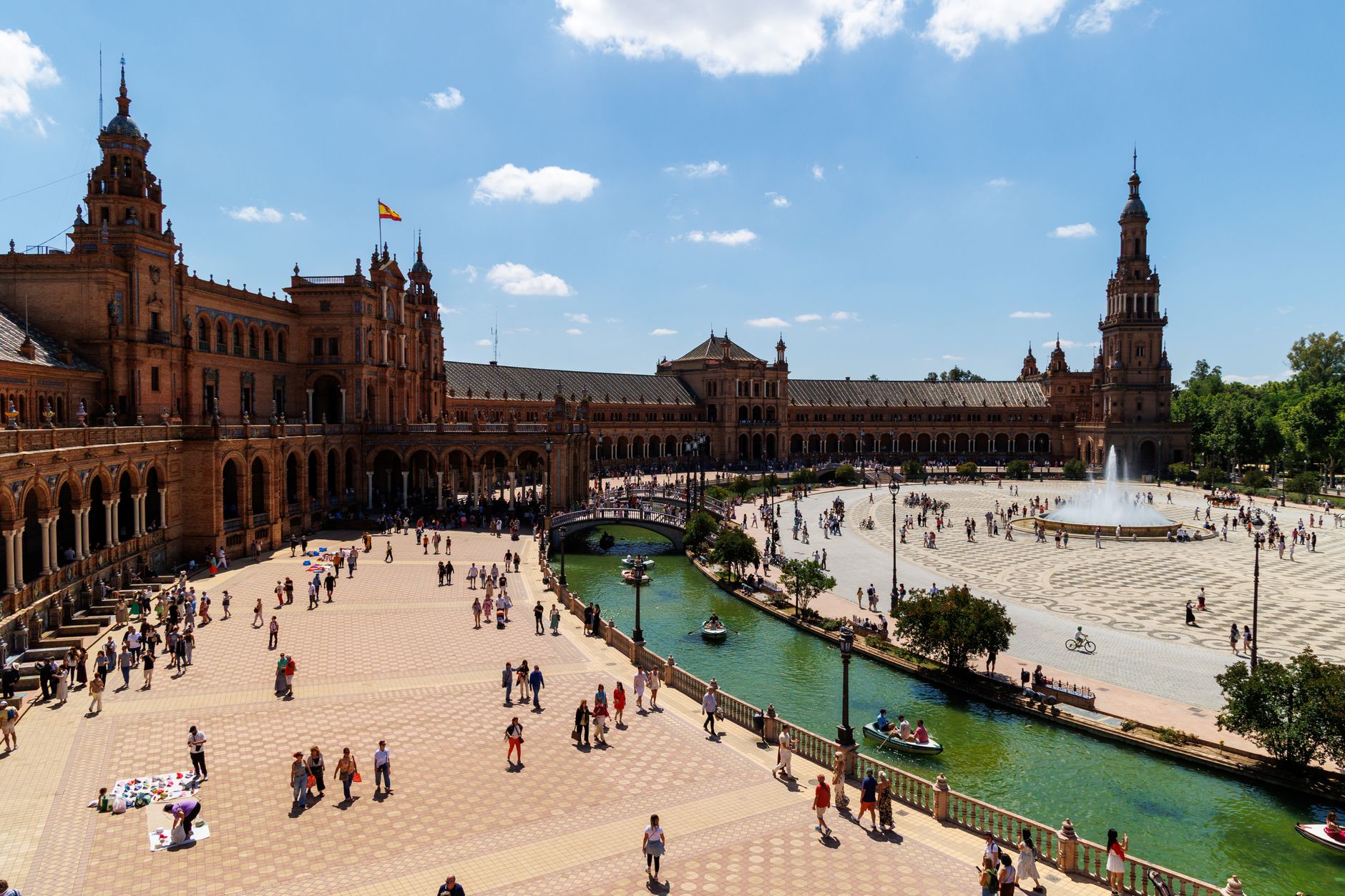 A vibrant scene of Plaza de España, Sevilla, capturing local culture and architecture under blue skies.