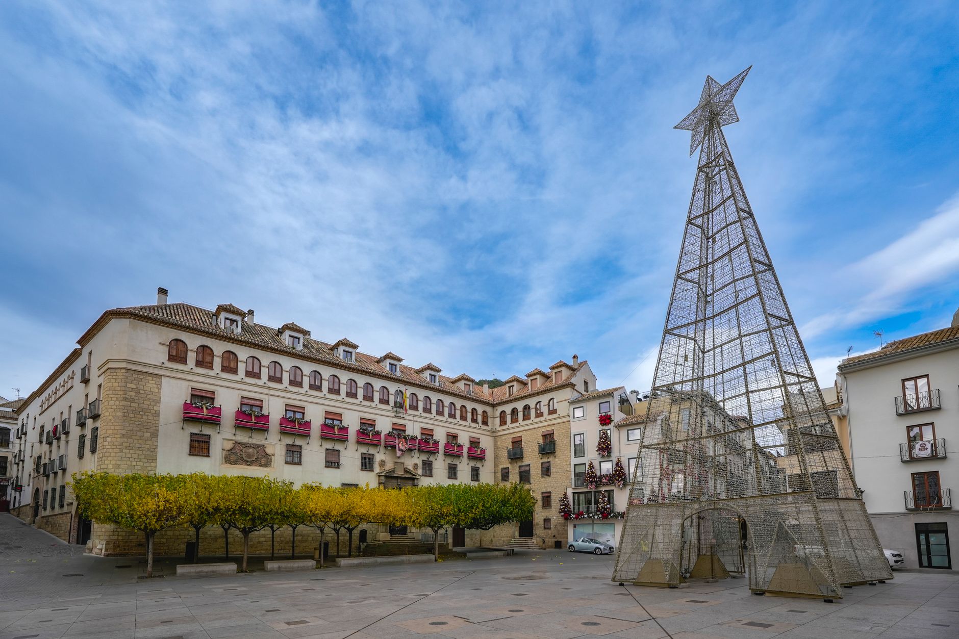 Festive square in Jaén, Spain with large star decoration building facade.