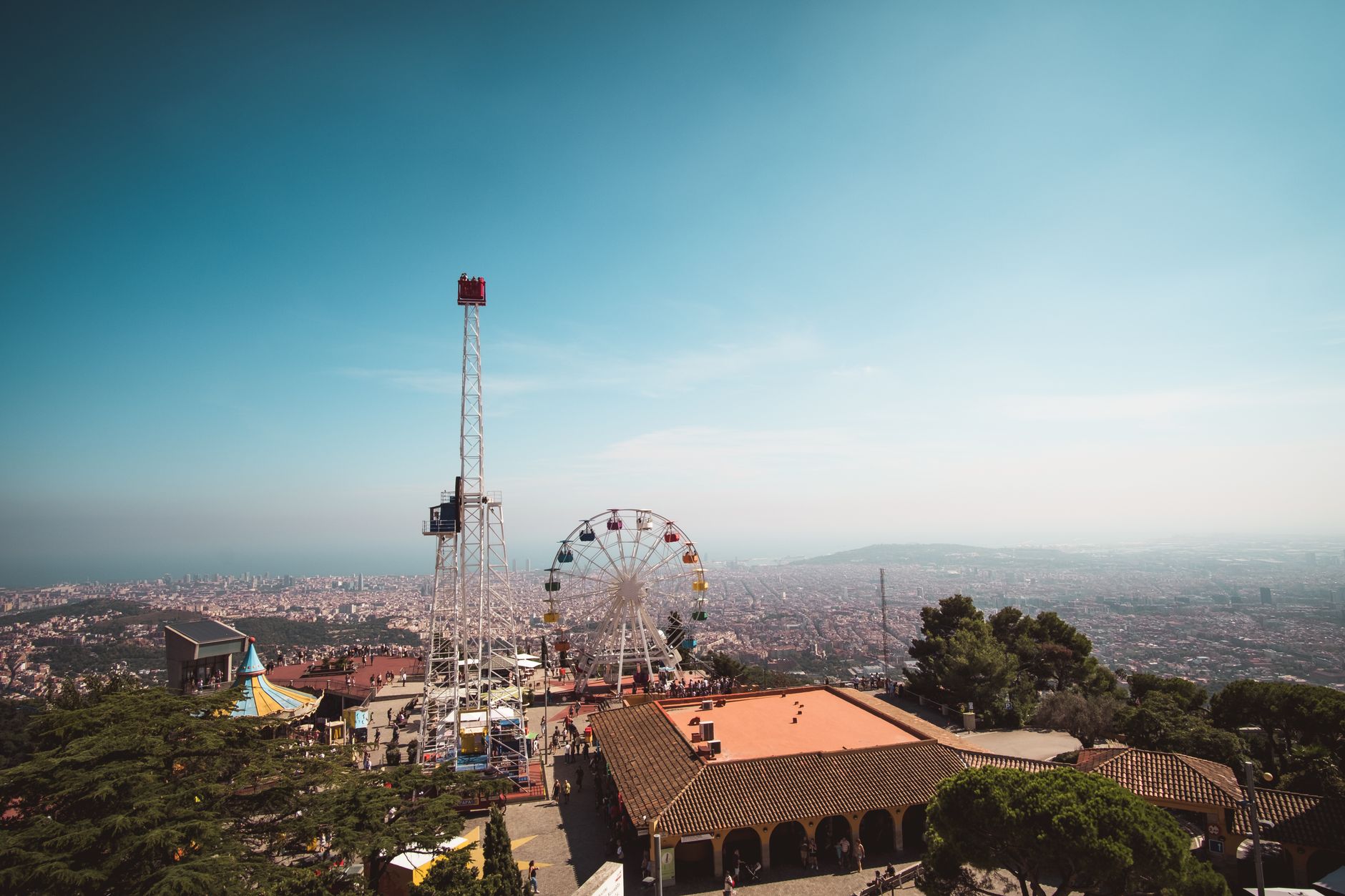 Aerial view of Ferris wheel and cityscape from Tibidabo Amusement Park, Barcelona.