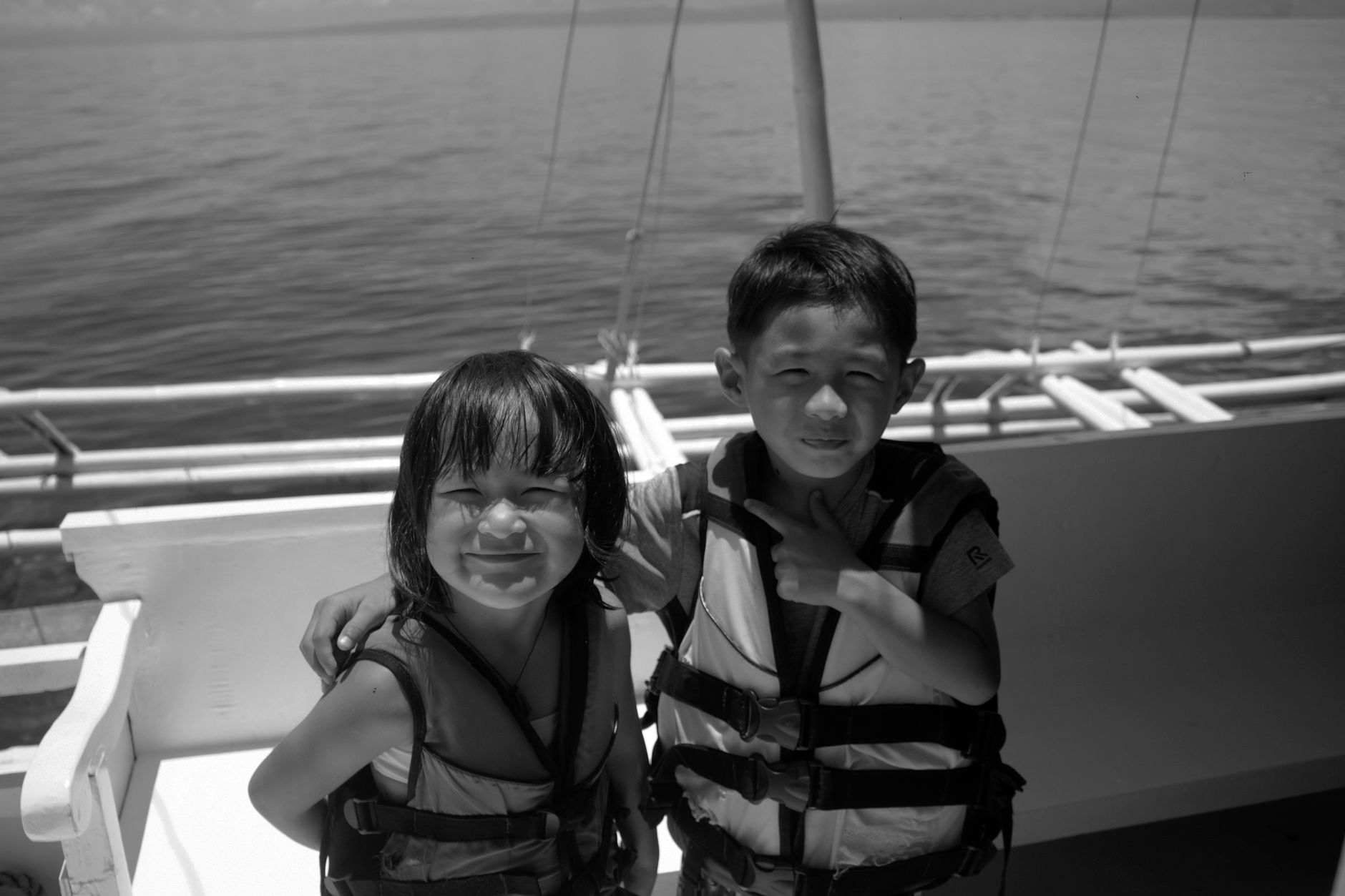 Smiling children in life vests on a sunny boat ride in Lapu-Lapu City.