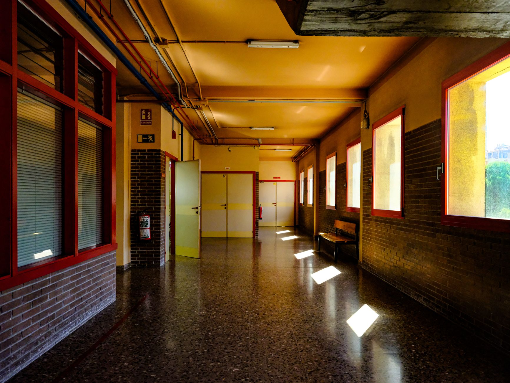 Bright corridor in a Zaragoza school with sunlight streaming through windows, creating a warm ambiance.